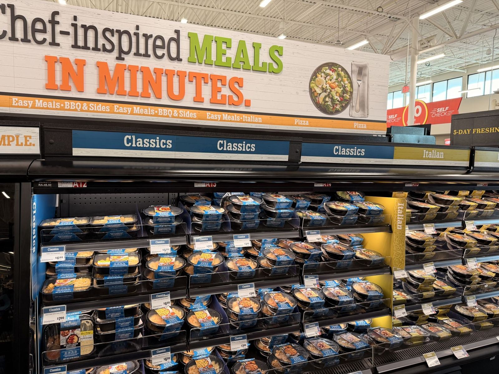 H-E-B wall of ready meals under a Chef-inspired Meals in Minutes sign, with comfort-food and Italian sections