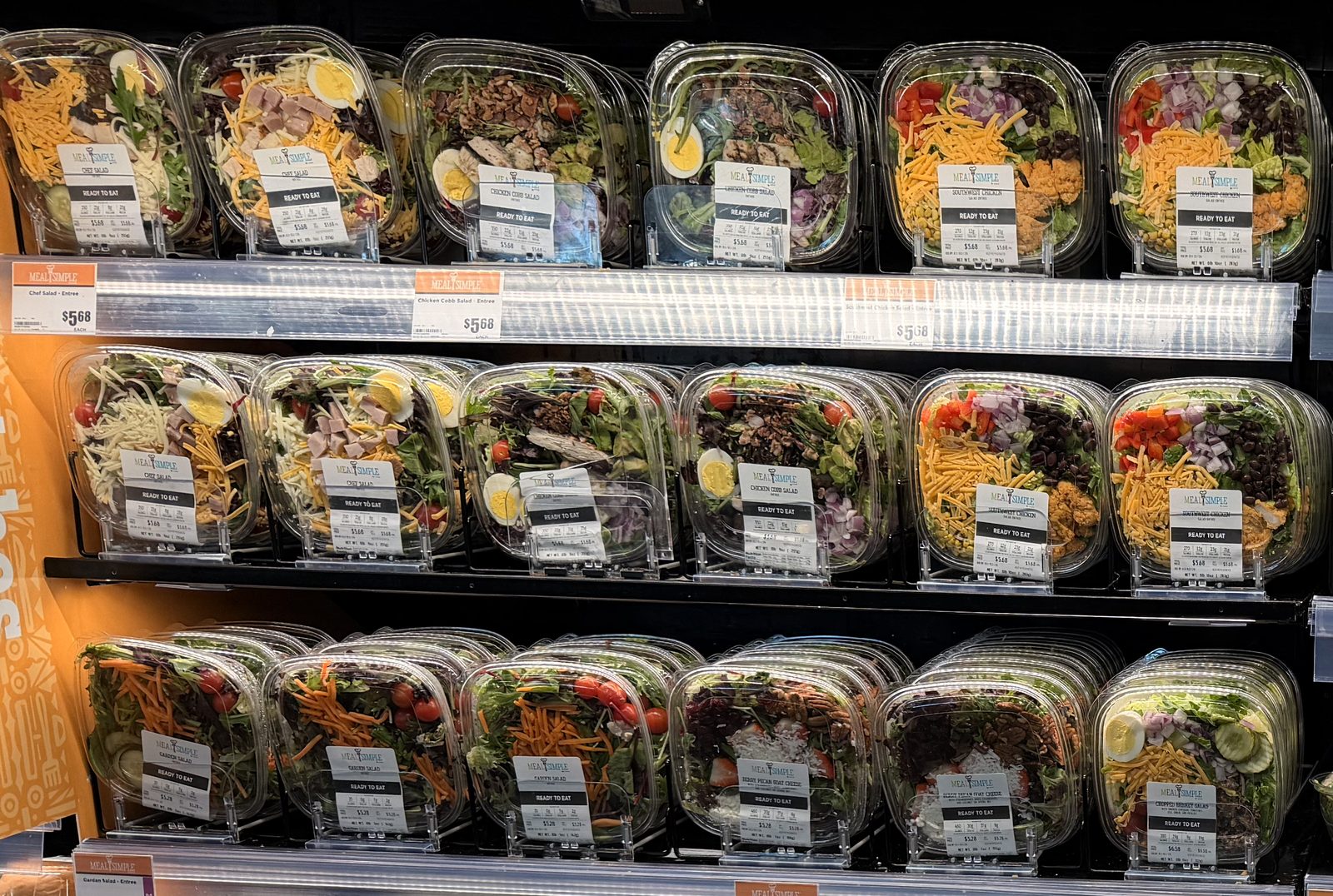 Close-up of H-E-B chef, Cobb and Southwest chicken salads at $5.68, topped with egg, ham, cheese, pecans and black beans