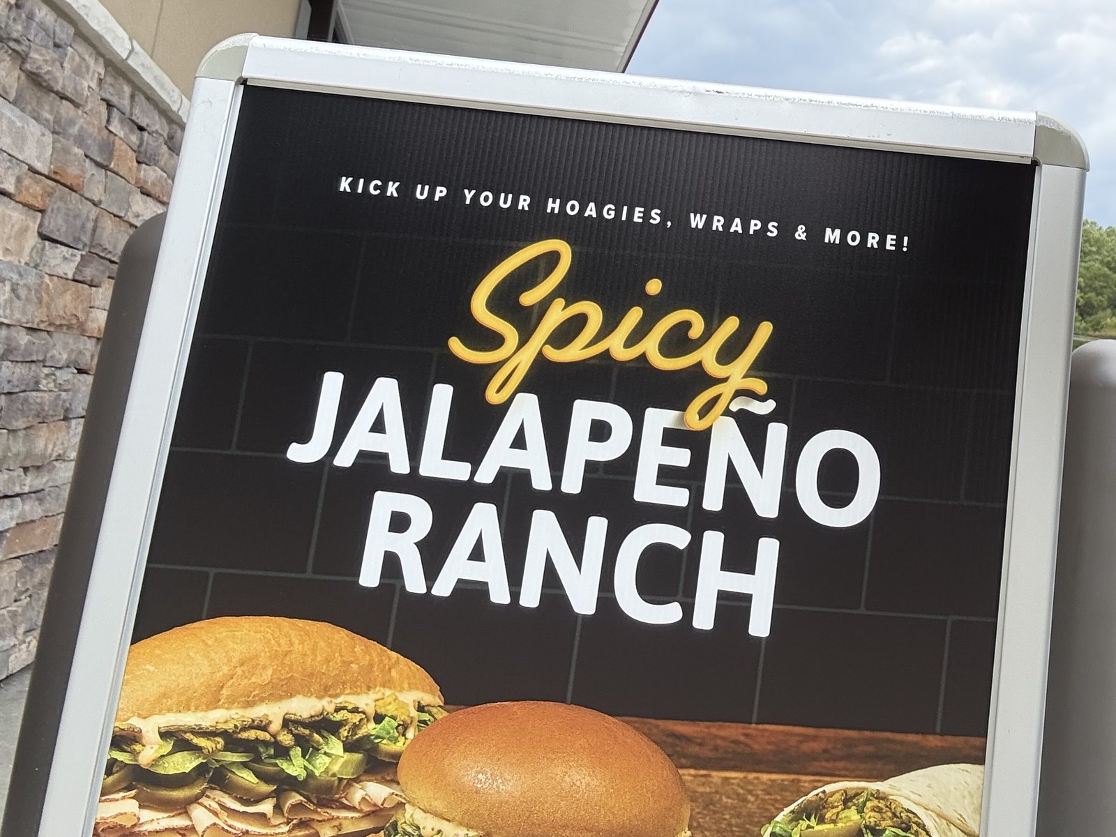 A Wawa sign outside the store: Kick up your hoagies, wraps & more! Spicy Jalapeño Ranch
